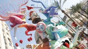 Las Fogueres de Sant Joan 2026 de Alicante son mucho más que cinco días de fiesta. El calendario festero arranca el 23 de mayo con la inauguración de la Exposición del Ninot y no termina hasta el 29 de junio con el Coso Multicolor — más de un mes de actos, desfiles, mascletàs y pólvora que transforman la ciudad semana a semana. El arranque oficial llega este viernes 5 de junio con el Pregón de Fiestas desde la Plaza del Ayuntamiento. Declaradas Fiesta de Interés Turístico Internacional, las Fogueres afectan a la movilidad de Alicante durante semanas — aquí tienes el programa completo y todo lo que necesitas saber para moverte. Programa oficial de las Fogueres de Sant Joan 2026 Miércoles 3 de junio — Encendido del alumbrado festero A las 21:30 horas, encendido oficial del alumbrado festero en la plaza del Ayuntamiento (por confirmar). Más de 650.000 luces LED iluminarán la ciudad durante las celebraciones. Viernes 5 de junio — Pregón: inicio oficial de las fiestas A las 18:30 horas, evento 'Música per a una Festa' con 1.100 músicos y 25 bandas congregados en la Plaza de España. A las 19:00 horas, Homenaje al Foguerer y Barraquer fallecidos en la Plaza de España. A las 19:30 horas, Desfile del Pregón entre la Plaza de España y la Plaza del Ayuntamiento. A las 21:00 horas, Pregón de Fiestas desde la Plaza del Ayuntamiento. A las 23:00 horas, Fiesta del Pregón en la Zona Volvo. El pregonero de 2026 es el artista alicantino de pop urbano Funzo. Sábado 6 de junio — Desfile del Ninot A las 19:00 horas, Desfile del Ninot a través del itinerario oficial entre Luceros y el Ayuntamiento. Las comisiones desfilan disfrazadas con motivos alegóricos al tema de su hoguera — uno de los desfiles más originales y divertidos de toda la fiesta. Domingo 7 de junio — Mascletà y Mostra de Folklore A las 14:00 horas, mascletà del ciclo 'Pólvora tot l'any' en avenida Unicef 6. A las 18:00 horas, III Mostra de Folklore Alacantí en la avenida de la Constitución: cuentacuentos, talleres de dansà, juegos tradicionales, artesanía y actuaciones de grupos de danzas locales y la Colla de Nanos i Gegants d'Alacant. Sábado 13 de junio — Entrada de Bandas A las 14:00 horas, mascletà en el centro comercial Gran Vía (plaza Agatangelo Soler). A las 19:00 horas, Entrada de Bandas y comisiones a través del itinerario oficial. Uno de los desfiles más esperados de toda la fiesta — decenas de bandas de música desfilan por el centro de Alicante con las comisiones de cada hoguera. Domingo 14 de junio — Clausura de la Exposición del Ninot A las 20:00 horas, clausura de la Exposición del Ninot y entrega de premios para conocer el Ninot Indultat 2026 tras el recuento de votos en la antigua Lonja del Pescado. El ninot indultat es el único monumento que se salva de la quema — elegido por votación popular. Miércoles 17 de junio — Arribada del Foc Por la tarde, colocación del remate de la Hoguera Oficial en la plaza del Ayuntamiento. A las 23:30 horas, espectáculo nocturno de luz y sonido 'Arribada del Foc' en la fachada de El Corte Inglés, frente a la plaza de la Estrella. Jueves 18 y viernes 19 de junio — Inicio del Concurso de Mascletàs en Luceros El jueves 18 a las 14:00 horas, primera mascletà en la Plaza de los Luceros (fuera de concurso), a cargo de Fuegos Artificiales del Mediterráneo. El viernes 19 a las 14:00 horas, segundo disparo del concurso oficial de mascletàs a cargo de Pirotecnia Crespo. A las 00:01 horas de la madrugada del viernes al sábado, plantà oficial de los monumentos infantiles y ninots al carrer. Sábado 20 de junio — Plantà de las hogueras adultas A las 00:01 horas de la madrugada del sábado al domingo, plantà oficial de las hogueras adultas y barracas. A las 9:00 horas, visita del jurado a las hogueras infantiles. A las 14:00 horas, tercera mascletà a cargo de Pirotecnia Turis. A las 17:00 horas, fallo del jurado de las hogueras infantiles. A las 20:30 horas, inauguración de Barracas y Racós. Domingo 21 de junio — Primera Ofrenda de Flores A las 00:01 horas, plantà oficial de las hogueras adultas. A las 9:00 horas, visita del jurado a las hogueras adultas. A las 14:00 horas, cuarta mascletà a cargo de Fuegos Artificiales del Mediterráneo. A las 17:00 horas, fallo del jurado adulto. A las 18:00 horas, primera sesión de la Ofrenda de Flores a la Virgen del Remedio a través de Alfonso El Sabio, la Rambla, calle San José, Concatedral, San Nicolás, Rafael Altamira y Plaza del Ayuntamiento. Lunes 22 de junio — Desfile de premios y segunda Ofrenda A las 11:00 horas, desfile de entrega de premios desde el Ayuntamiento hasta la Rambla. A las 13:00 horas, Colla de Nanos i Gegants. A las 14:00 horas, quinta mascletà a cargo de Pirotecnia Pibierzo. A las 18:00 horas, segunda sesión de la Ofrenda de Flores. Martes 23 de junio — Desfile Folclórico Internacional A las 12:30 horas, entrega de premios de la Ofrenda de Flores en el Mercadito de Fogueres. A las 14:00 horas, sexta mascletà a cargo de los Hermanos Ferrández. A las 18:00 horas, Dansà d'Alacant en torno a la Hoguera Oficial en la plaza del Ayuntamiento. A las 19:00 horas, Desfile Folclórico Internacional por el recorrido oficial entre Luceros y Ayuntamiento. Miércoles 24 de junio — San Juan: la Nit de la Cremà A las 14:00 horas, séptima y última mascletà a cargo de Pirotecnia Alta Palancia. A las 20:00 horas, misa oficial de Fogueres en la Concatedral de San Nicolás. A las 00:00 horas, disparo de la monumental Palmera desde la cumbre del Monte Benacantil a cargo de Pirotecnia Hermanos Ferrández, seguido del inicio de la Nit de la Cremà. La Hoguera Oficial en la plaza del Ayuntamiento es la primera en arder. Del 25 al 29 de junio — Fuegos artificiales y Coso Multicolor Entre el 25 y el 29 de junio, castillos de fuegos artificiales a las 00:00 horas desde el Postiguet, a la altura del Paseito Ramiro, en el nuevo emplazamiento autorizado por Costas tras la salida obligada de la playa del Cocó. El lunes 29 de junio, último gran acto con el Coso Multicolor — las Belleas y Damas de cada comisión llenarán de color y confeti las inmediaciones del Centro Comercial Gran Vía. Cortes de tráfico y movilidad durante las Fogueres Las Fogueres transforman completamente la movilidad de Alicante. Con 182 hogueras entre adultas e infantiles y cerca de medio centenar de portadas de barracas repartidas por toda la ciudad, cientos de calles quedan cortadas al tráfico rodado durante la semana grande. El Ayuntamiento establece un circuito permeable en el centro con la velocidad limitada a 20 km/h. La circulación perimetral se recomienda por la Vía Parque y las grandes avenidas periféricas. Los días de mayor impacto en el tráfico son el viernes 5 de junio — Desfile del Pregón cortando el eje Plaza de España-Rambla-Altamira desde las 19:30 —, el sábado 13 — Entrada de Bandas desde las 19:00 — y la madrugada del 23 al 24 de junio, cuando la cremà corta decenas de calles simultáneamente. El tráfico de paso desde Alicante con destino Valencia se desviará por itinerarios alternativos durante los días de mayores restricciones. Transporte público: TRAM y autobús reforzados El TRAM d'Alacant y los autobuses urbanos refuerzan sus frecuencias durante toda la semana grande con servicios especiales nocturnos — especialmente en las noches del 23 y 24 de junio. Las paradas del TRAM en el centro — Luceros y Mercado — son los mejores puntos de entrada al epicentro festivo. El Ayuntamiento recomienda dejar el coche en zonas periféricas y acceder al centro en transporte público. Fuente: Federació de Les Fogueres de Sant Joan d'Alacant, Ayuntamiento de Alicante, Alicante ExtraÚltima actualización: 26 de mayo de 2026